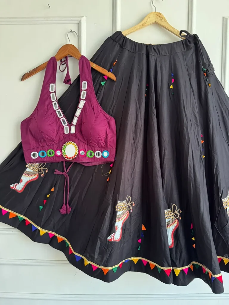 Wine halter choli with mirror work and a black lehenga with anklet artwork on hangers