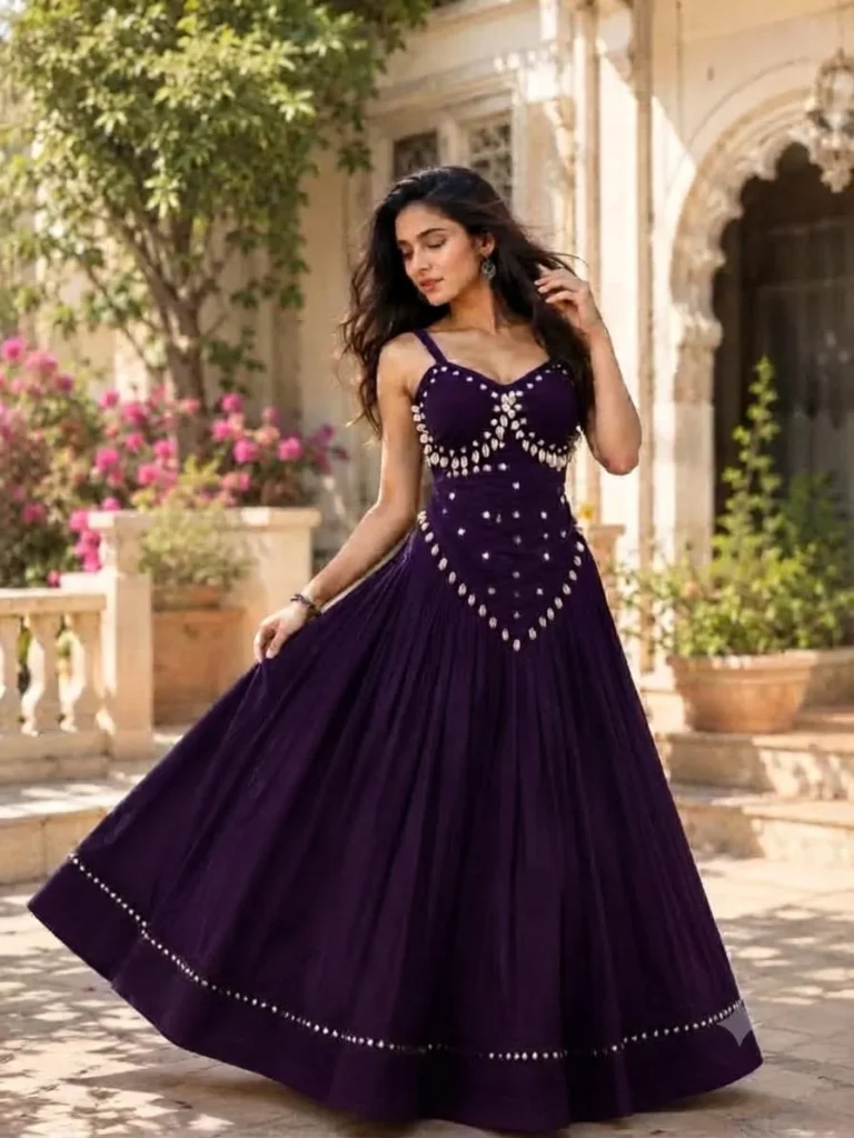 Model in a deep plum flared gown with shell and mirror embellishments